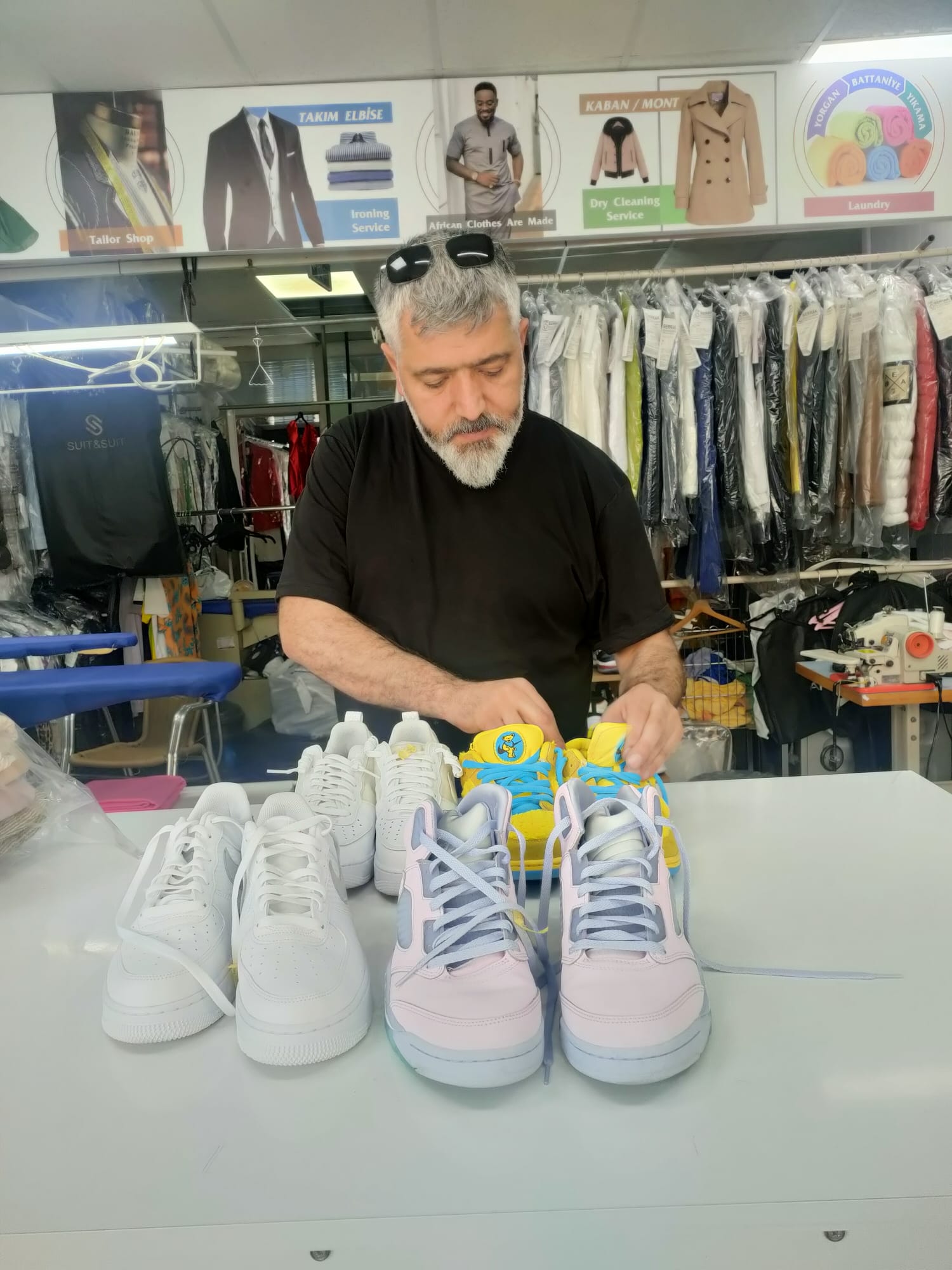 Temizlenmiş spor ayakkabıları tezgâhta kontrol eden usta
